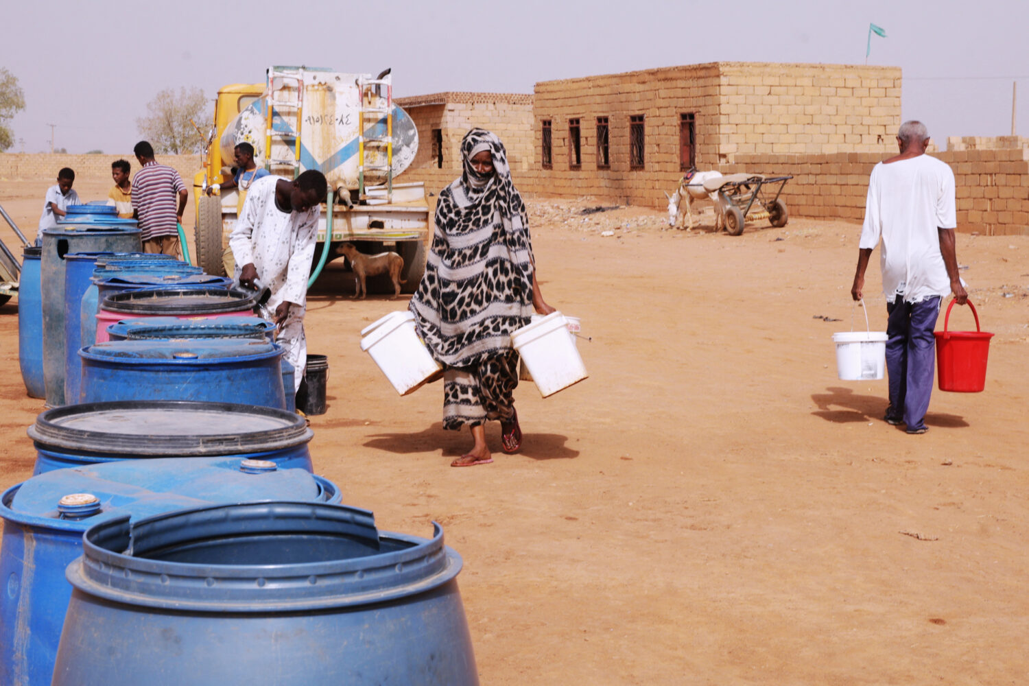 FILE - People fill water containers at a free distribution point amid water outages in Khartoum, Su...