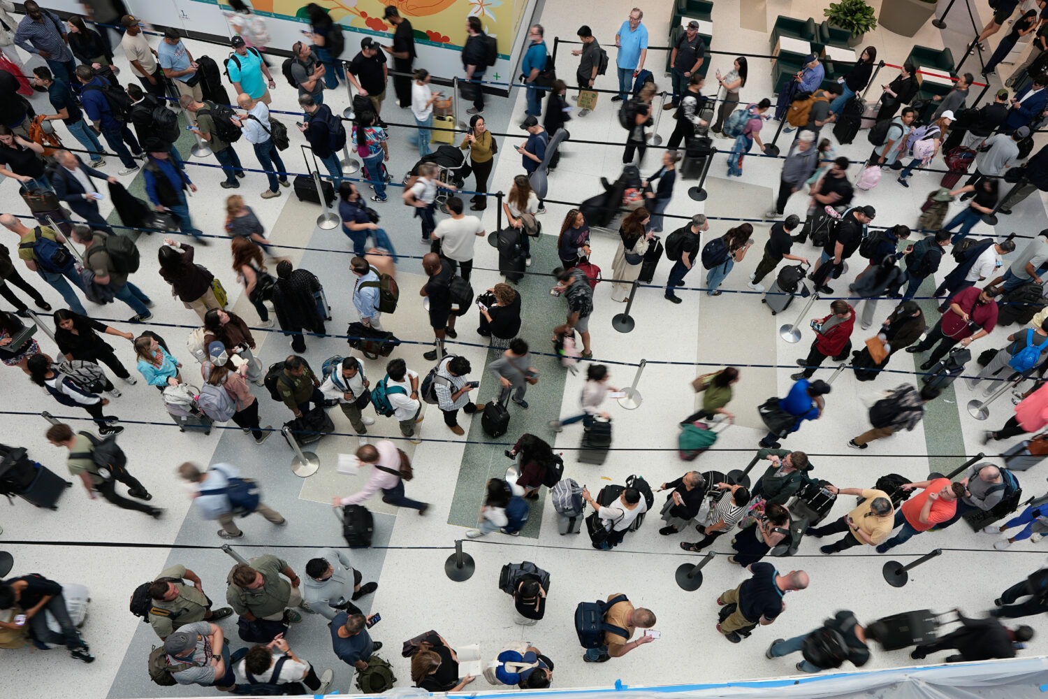 FILE - Travelers wait in long security checkpoint lines at George Bush Intercontinental Airport Mar...