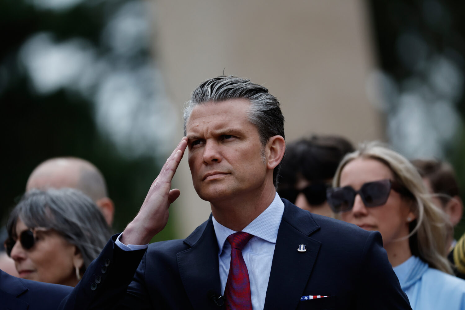 U.S. Defense Secretary Pete Hegseth salutes during a ceremony at the US cemetery to commemorate the...