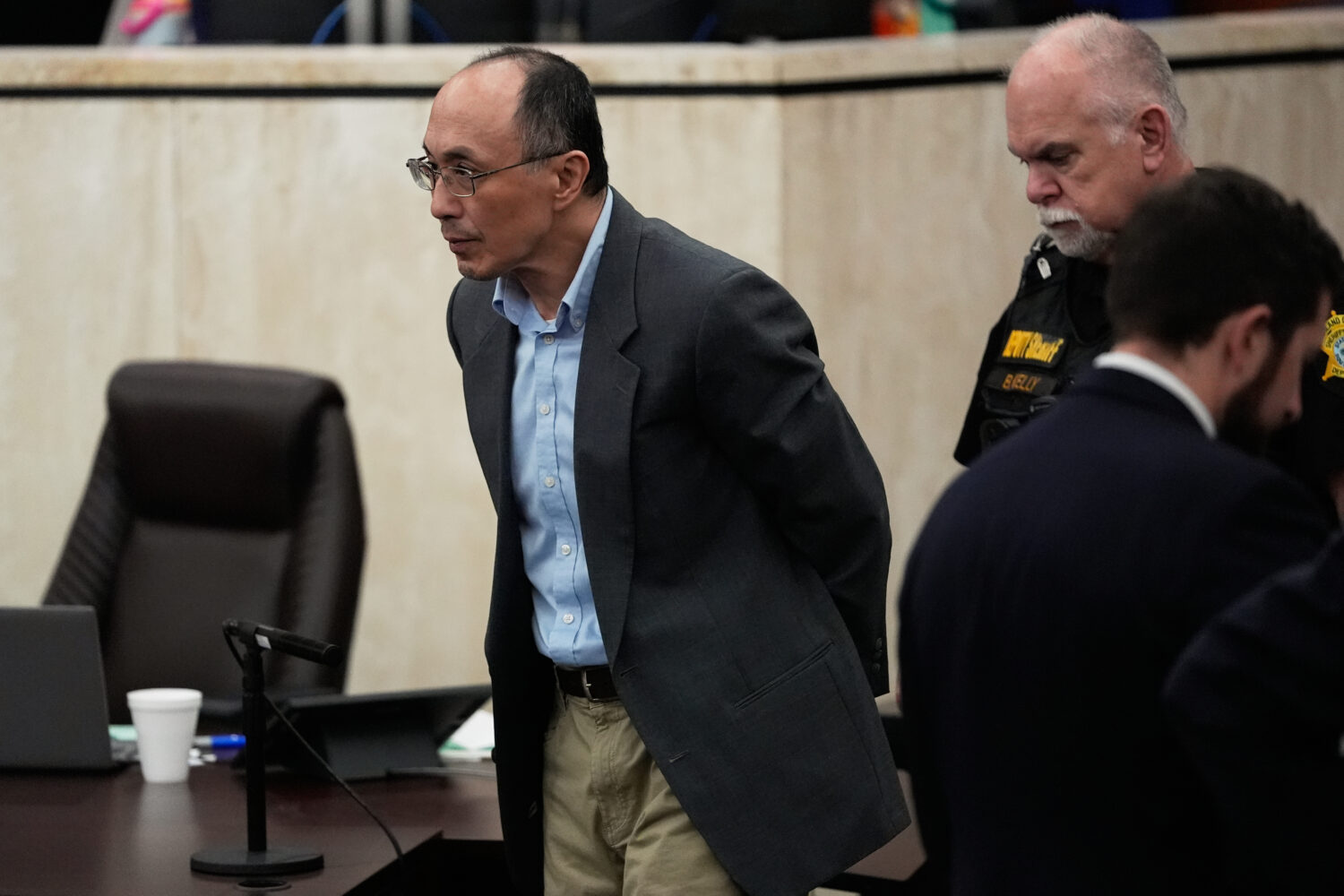 Chikei Rick Chow, left, accused in the 2023 fatal shooting of a Black 14-year-old, is escorted in t...