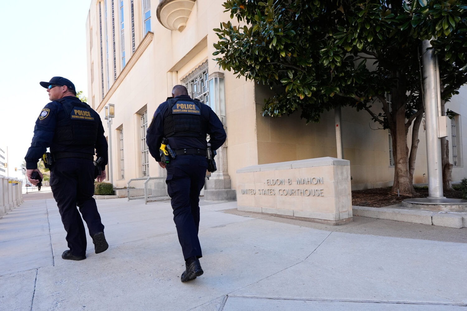 FILE - Officers with the Department of Homeland Security walk on the sidewalk outside the Eldon B. ...