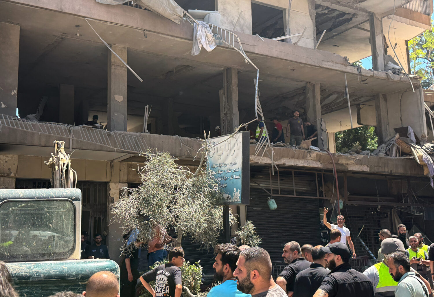 People gather at the site of an Israeli airstrike that struck an apartment in Dahiyeh, Beirut's sou...