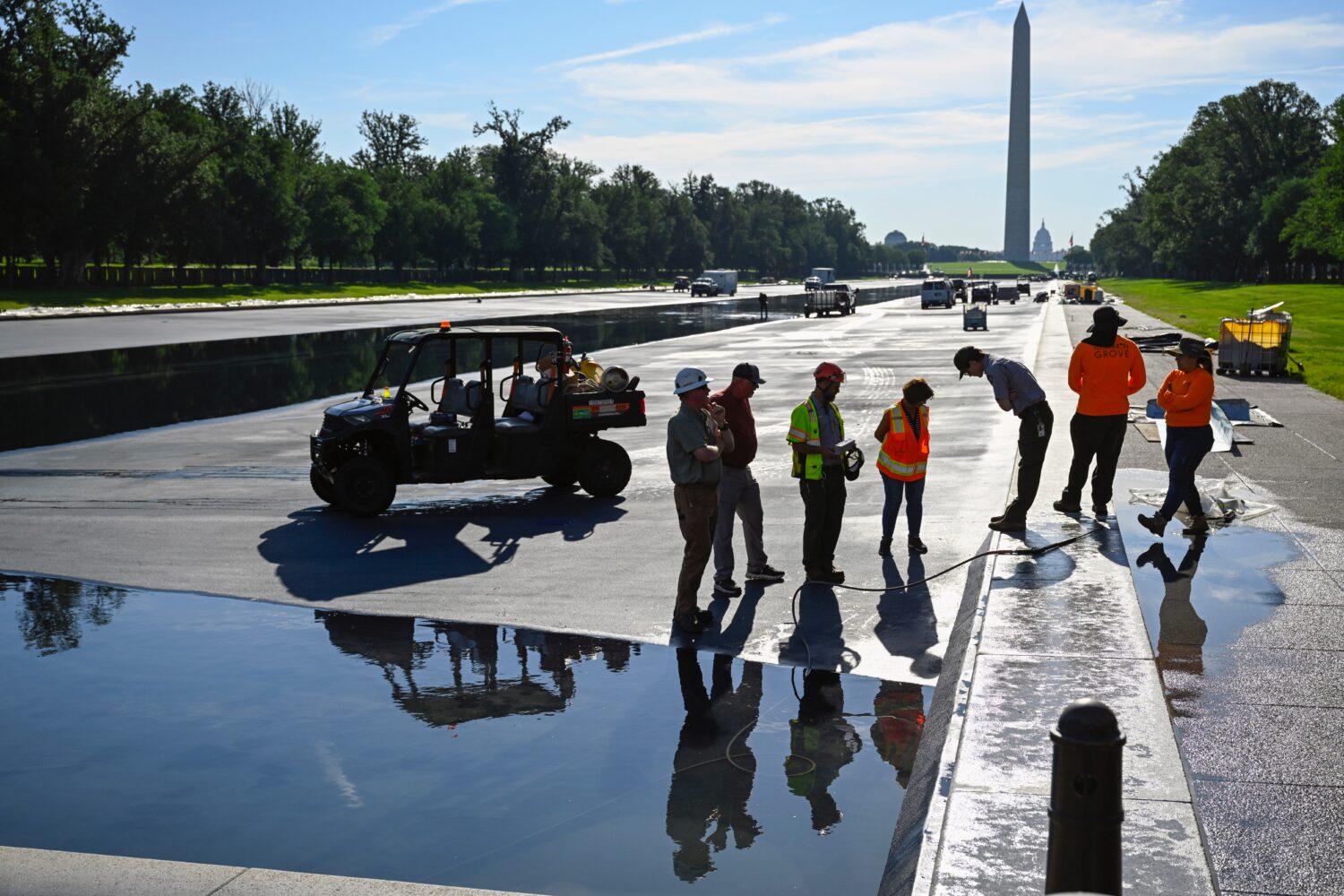 Workers refill the Lincoln Memorial Reflecting Pool after several months of repairs on Friday, June...