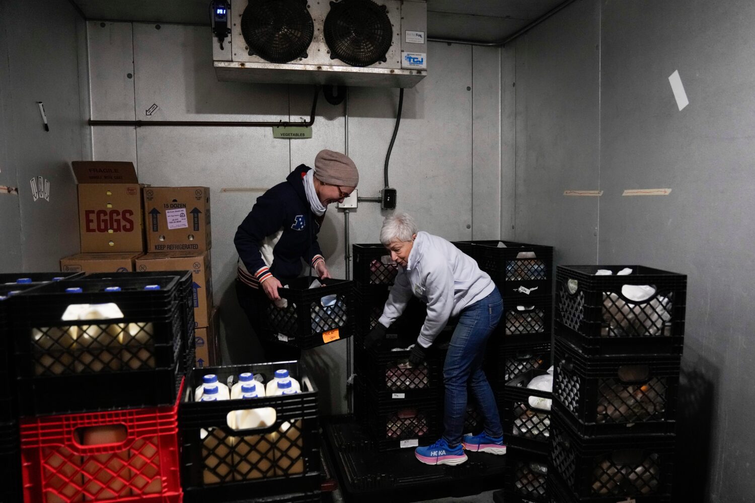 FILE - Volunteers Anja Lichtenau, left, and Marlene Rotstein organize food in a walk-in refrigerato...