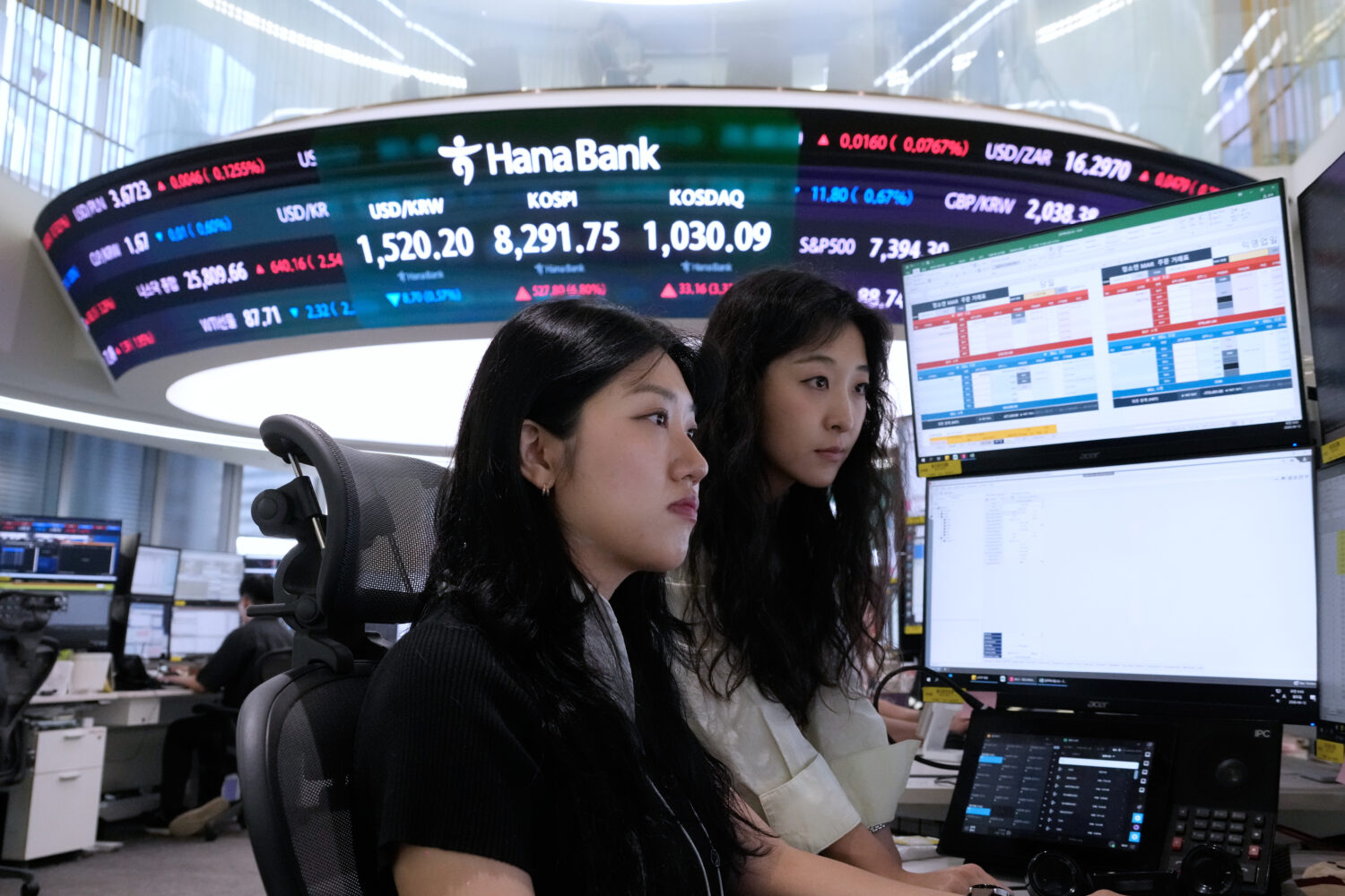 Currency traders watch monitors at the foreign exchange dealing room of the Hana Bank headquarters ...