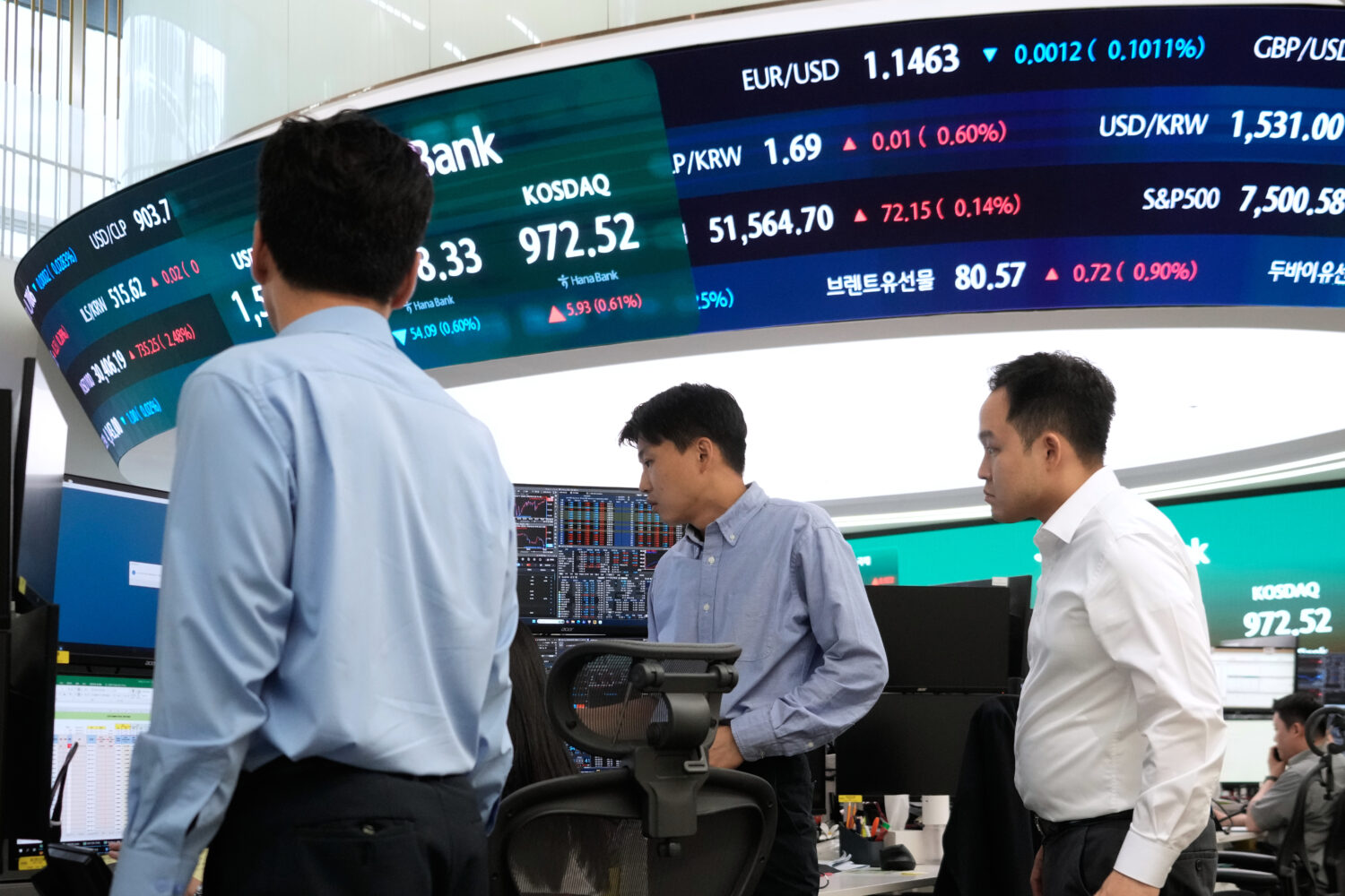 Currency traders work at the foreign exchange dealing room of the Hana Bank headquarters in Seoul, ...