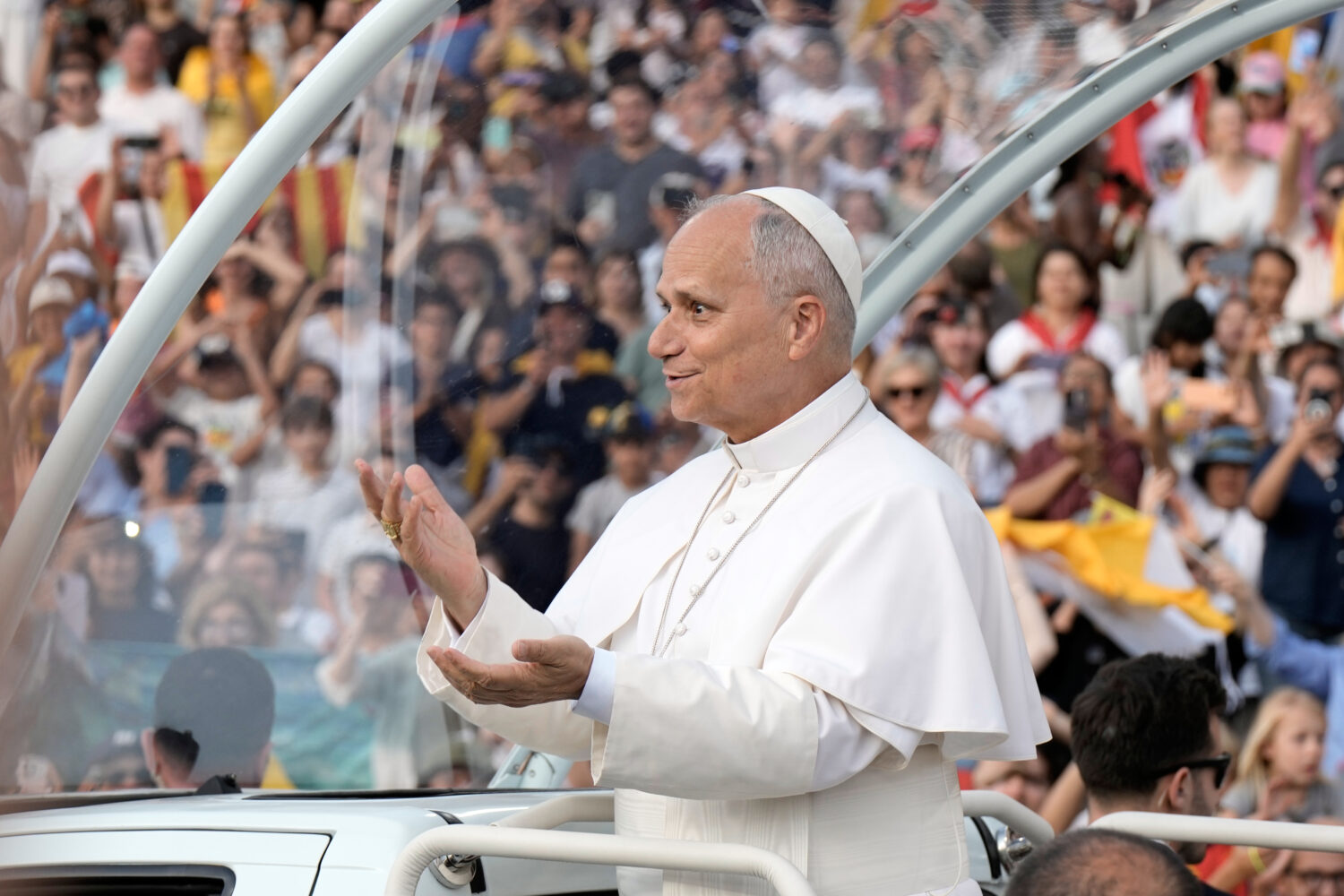 Pope Leo XIV makes a six-seven hand gestures as he arrives to attend a prayer vigil at Lluis Compan...
