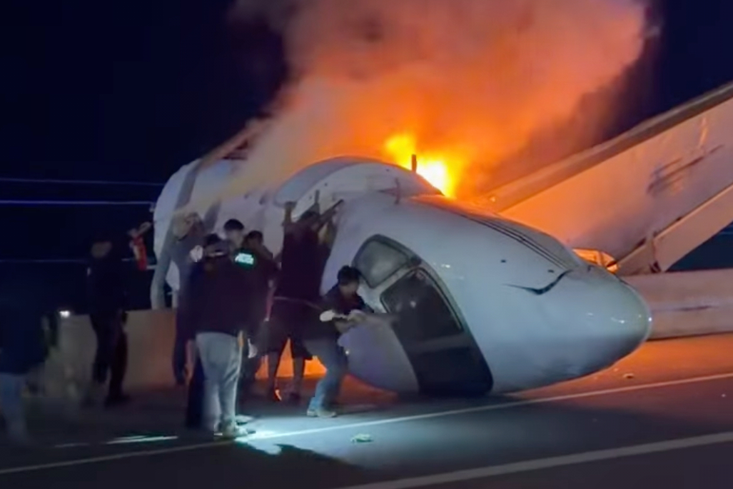 People attempt to pull passengers out of a plane after it crashed on a highway Tuesday, June 16, 20...