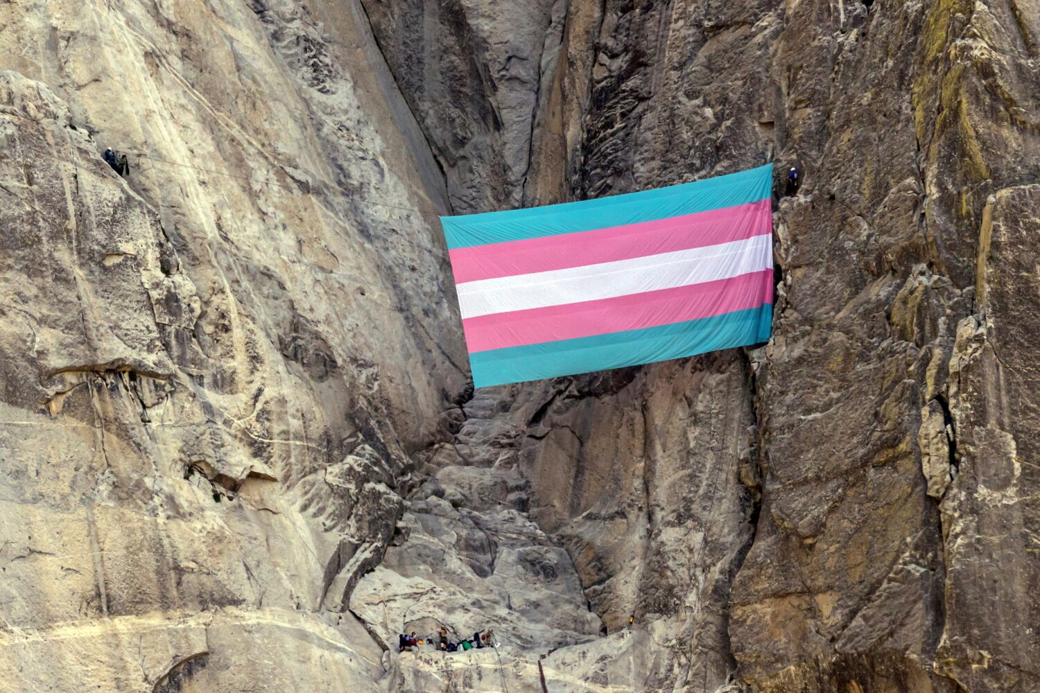FILE - A group of climbers unfurl a trans pride flag on El Capitan in Yosemite National Park, Calif...