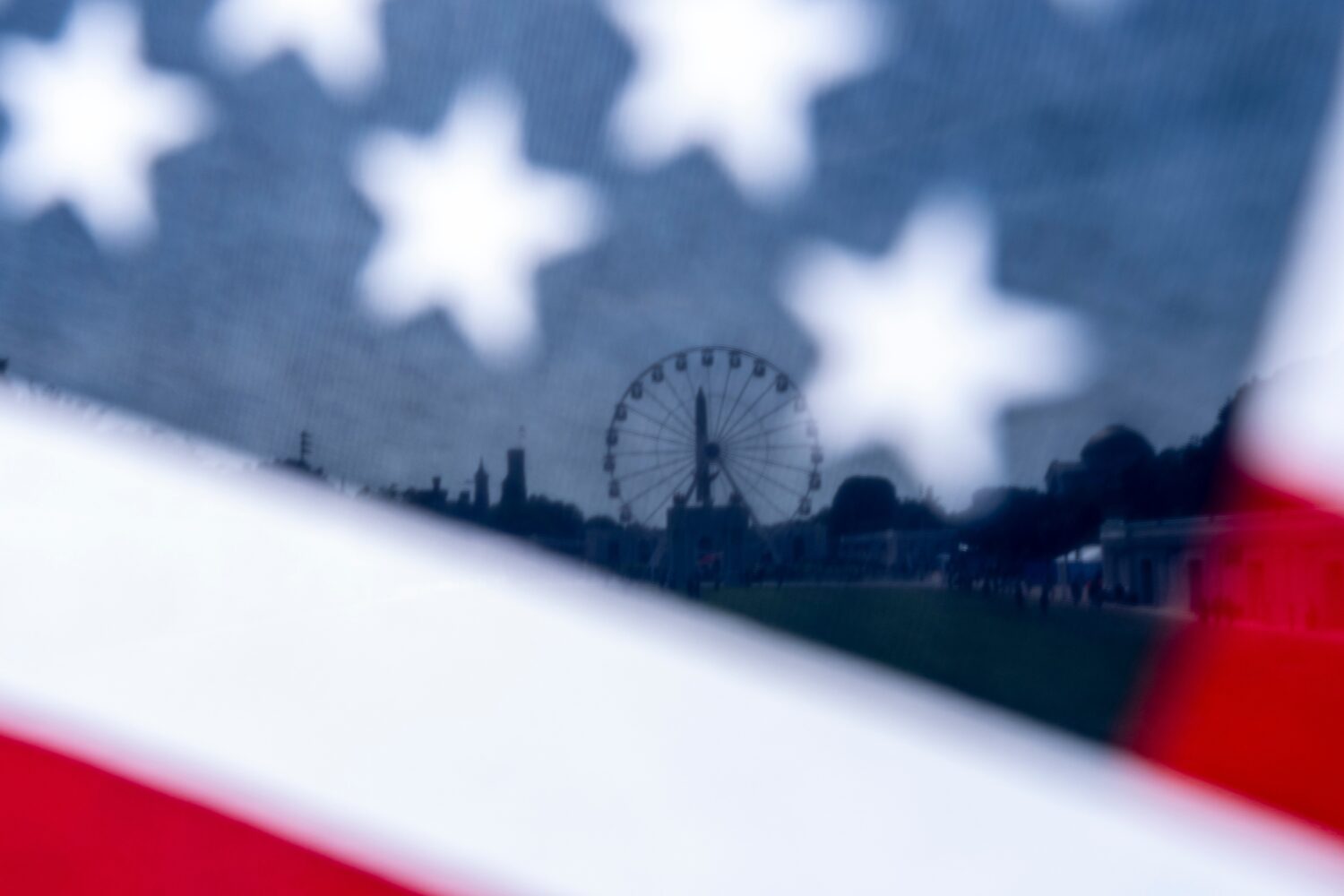 The Great American State Fair on the National Mall is seen through an American flag, Tuesday, June ...