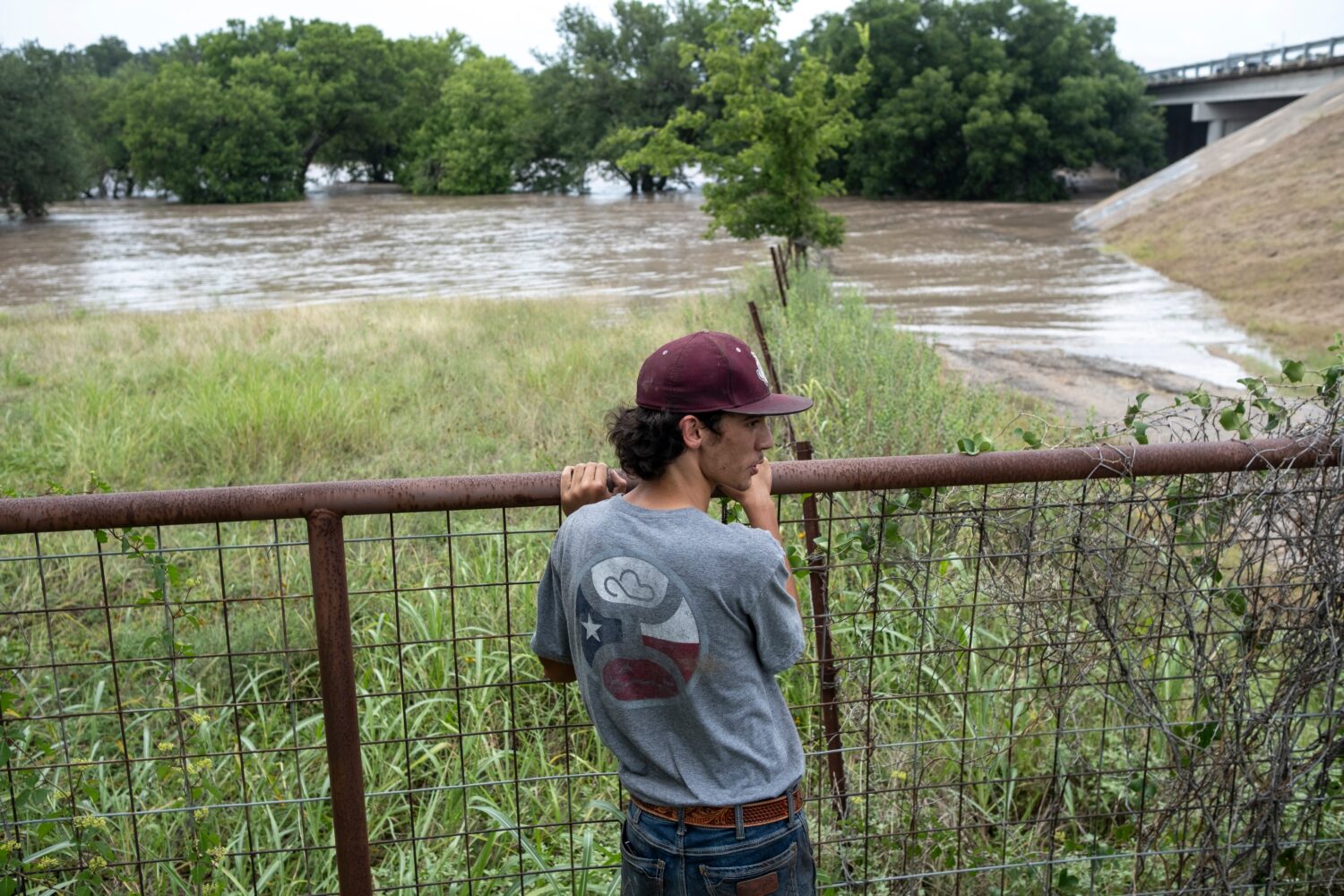 Hugh Ghormley watches as water moves along the Pedernales River at the Blanco County Fair and Rodeo...