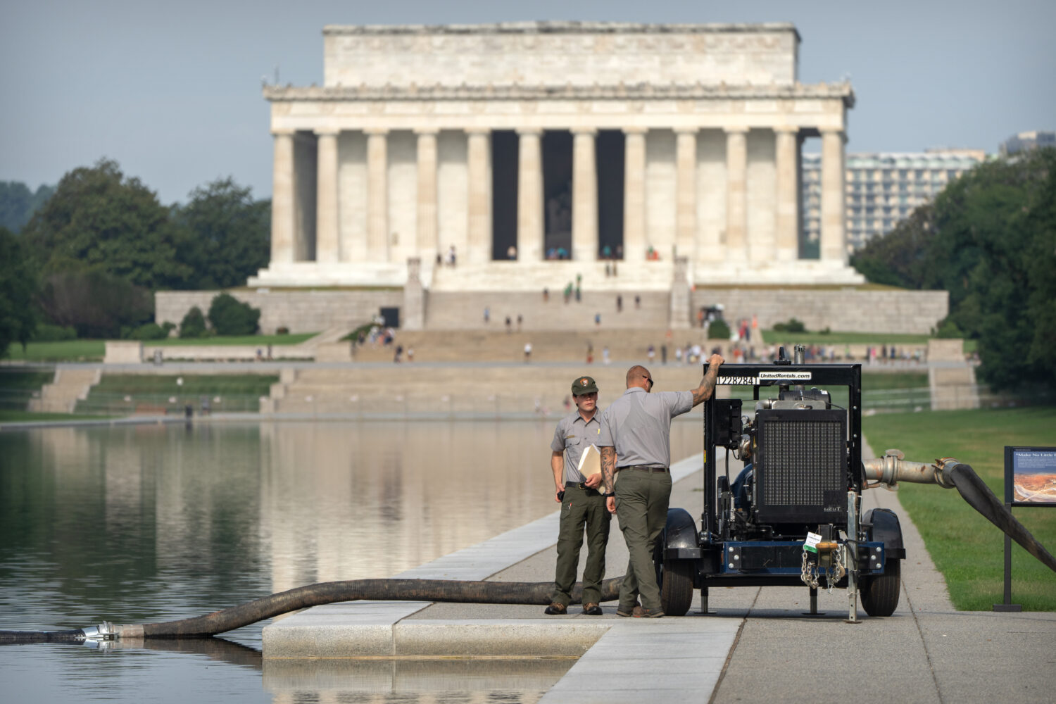 National Park Service workers stand near a pump placed next to the Lincoln Memorial Reflecting Pool...