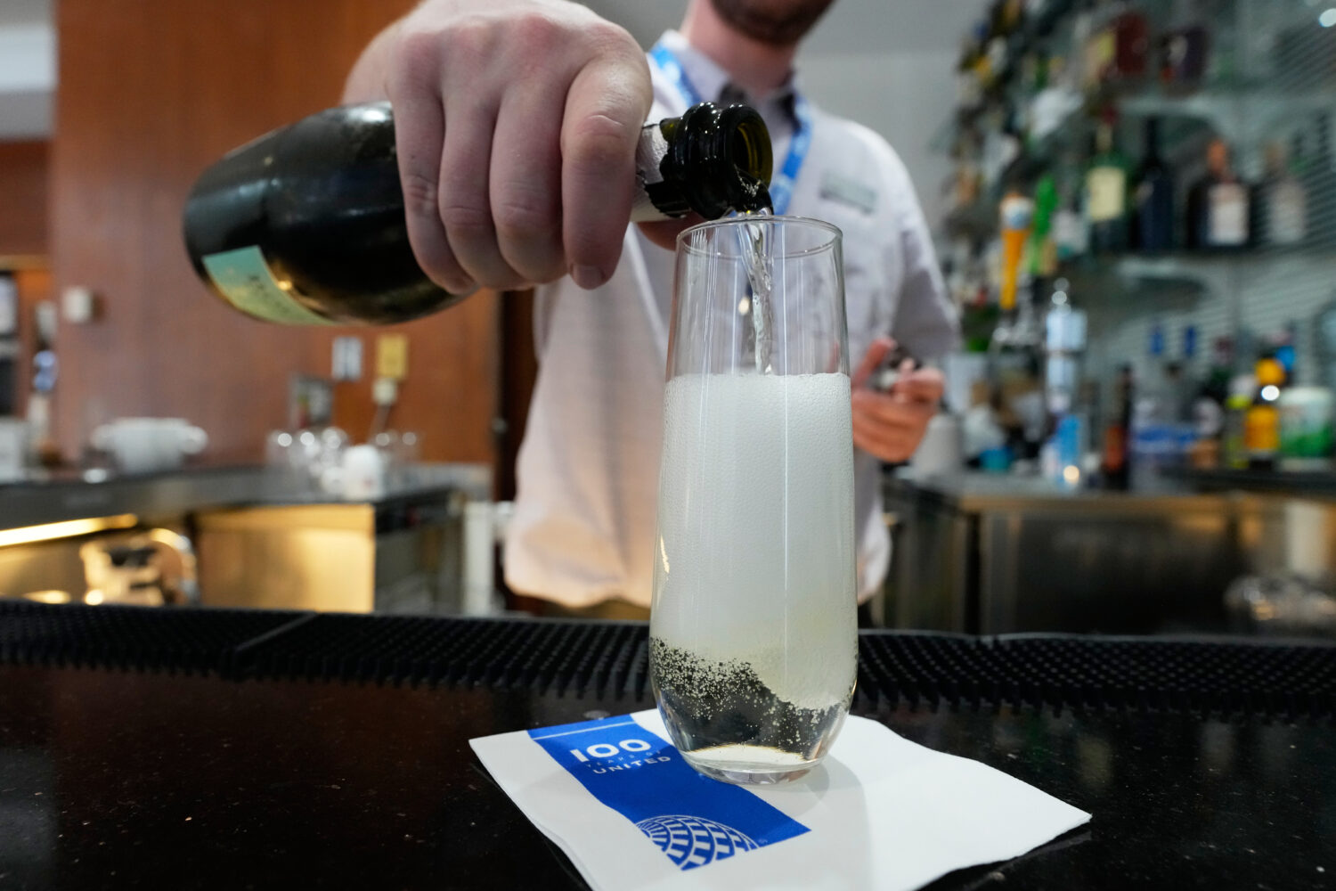 A bartender pours a glass of sparkling wine at the United Club lounge, Monday, June 29, 2026, in Mi...