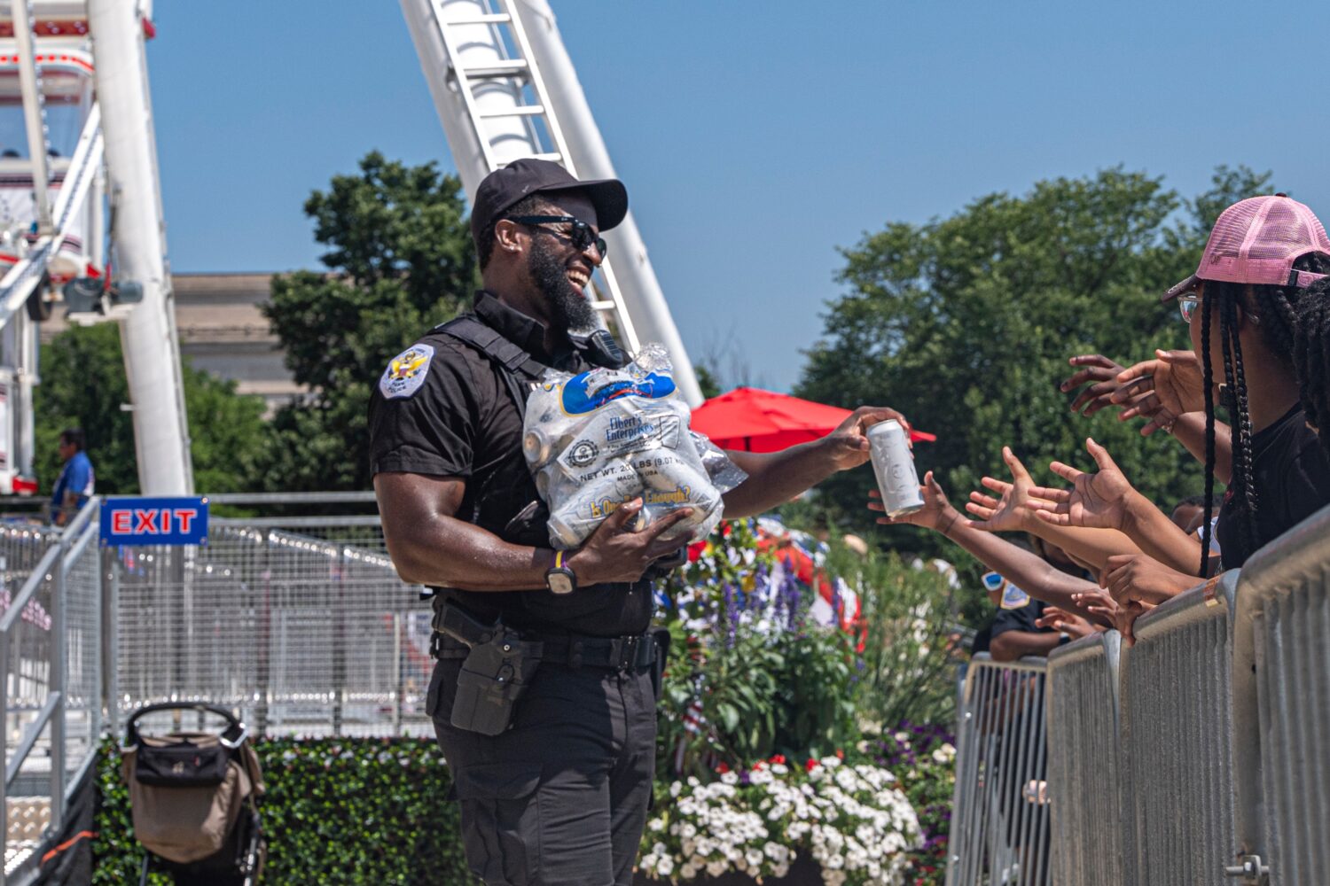 Children reach for cold bottles of water from U.S. National Park Police Officer R. Douglass as they...