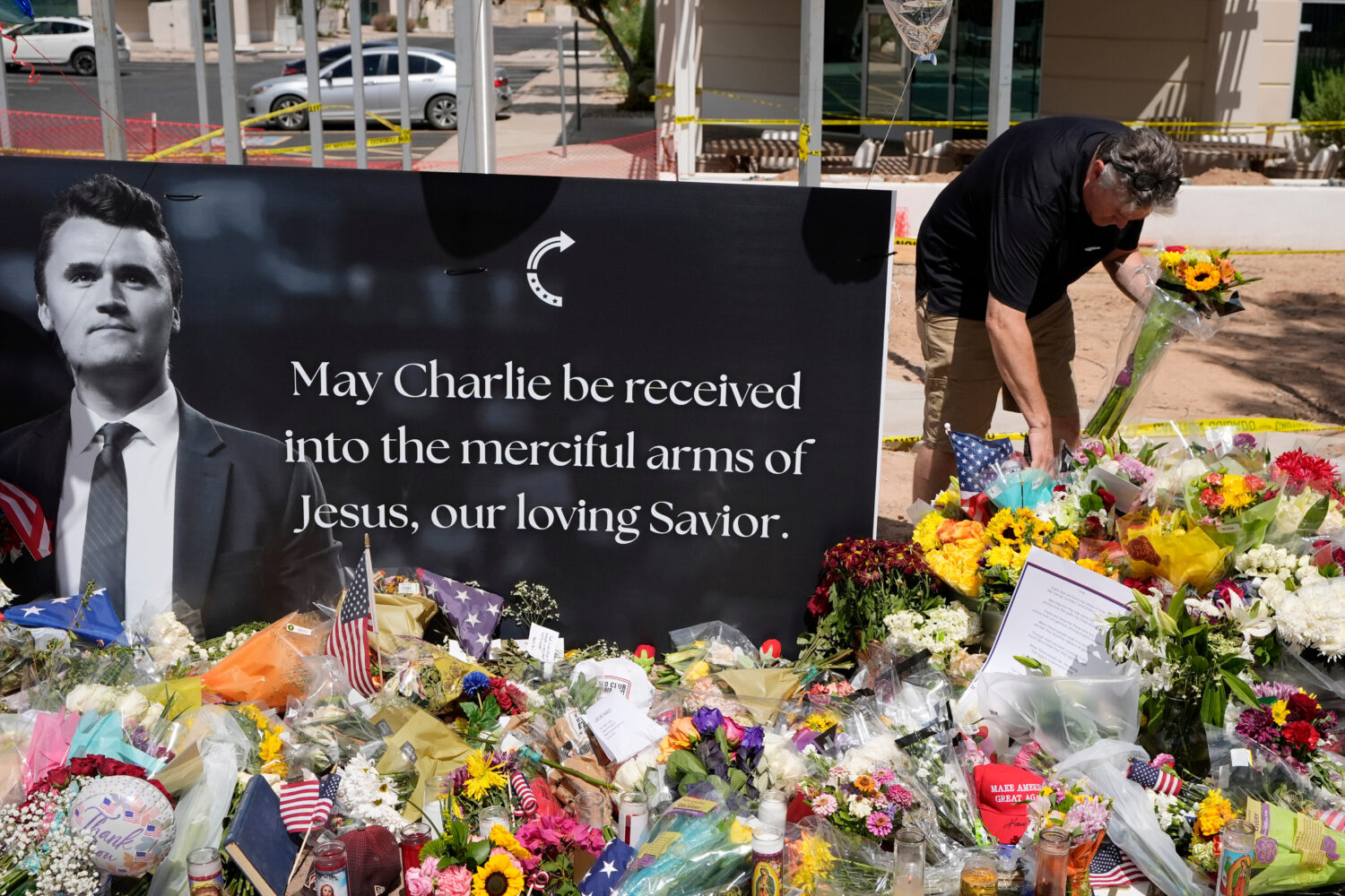 FILE - A well-wisher places flowers at a makeshift memorial set up for Charlie Kirk at Turning Poin...