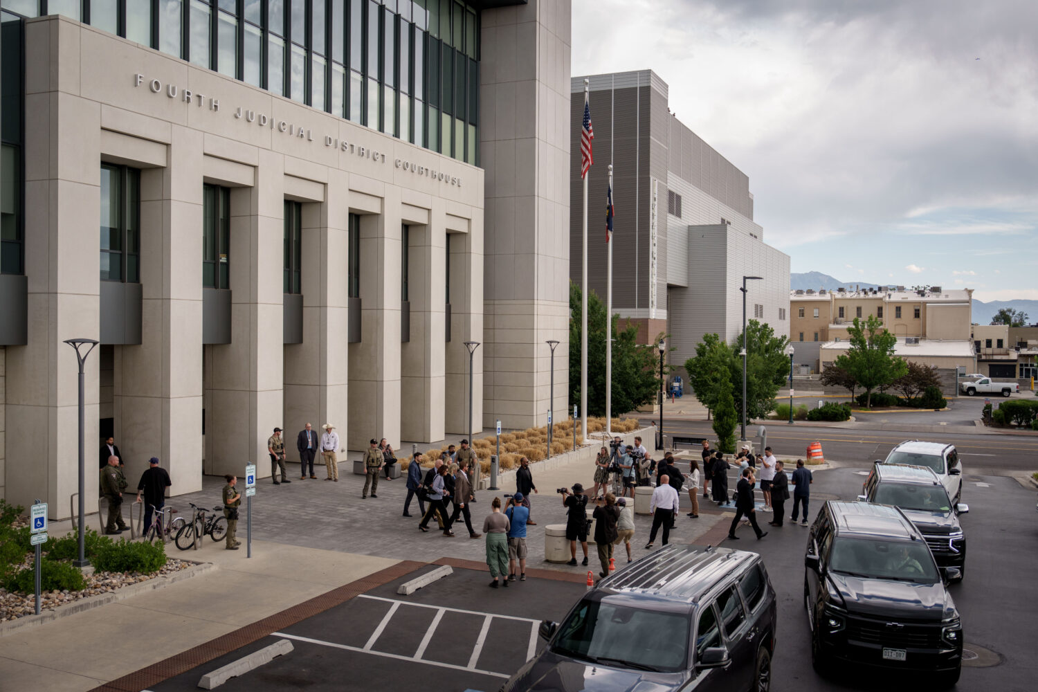 Journalists gather around as Charlie Kirk's parents exit with security guards after a preliminary h...