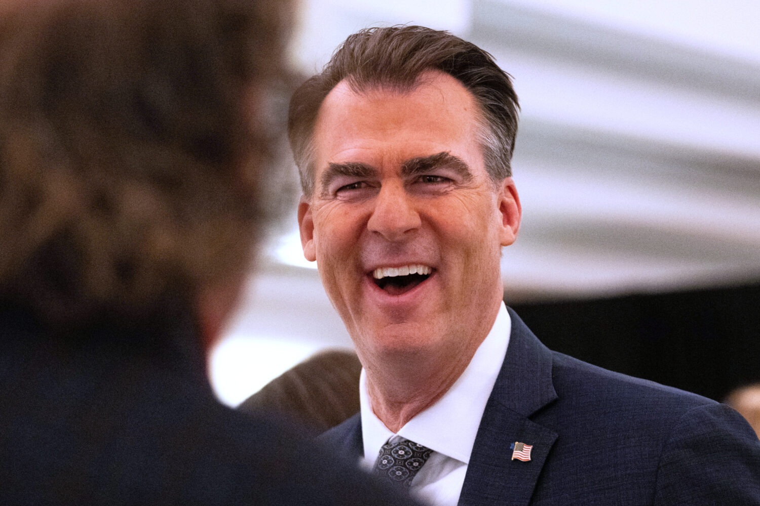 FILE - Oklahoma Gov. Kevin Stitt speaks with an individual following an event at the National Gover...
