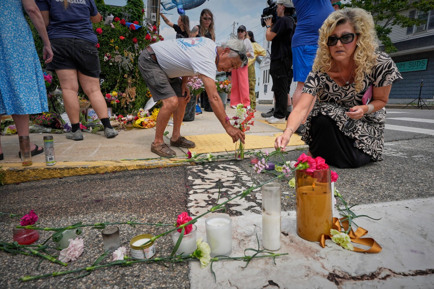 Mourners place flowers and candles in Biddeford, Maine, Wednesday, July 15 2026, near the blood-sta...