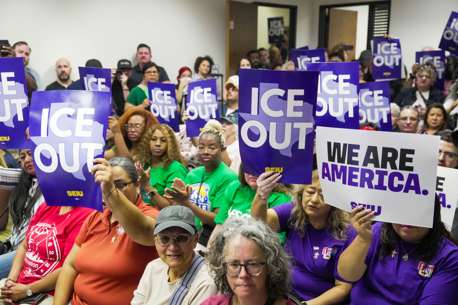 Community members hold signs reading "ICE Out" during a community vigil for Lorenzo Salgado Araujo ...