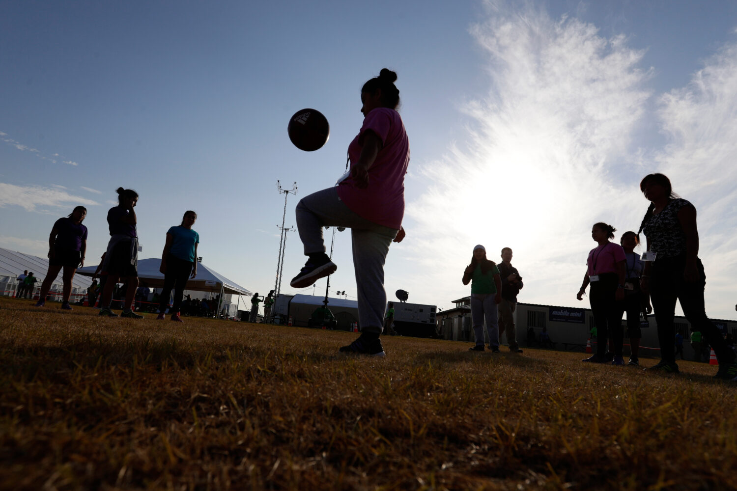 FILE - Immigrants play soccer at a new U.S. government holding center for migrant children, in Carr...