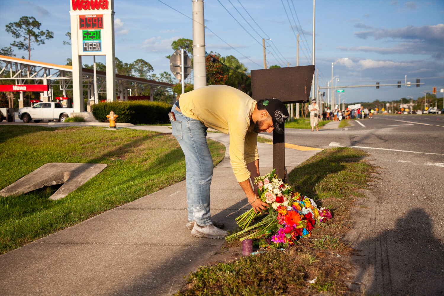 Edgar Olalde, of Jacksonville, who knew the victim from his store, lays a bouquet of flowers during...