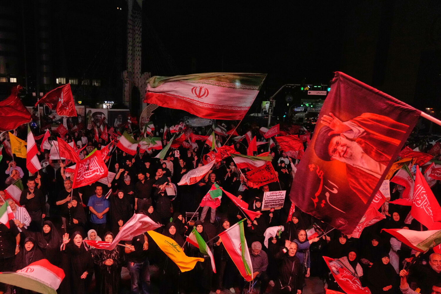 Pro-government demonstrators wave Iranian and religious flags in a gathering commemorating the late...