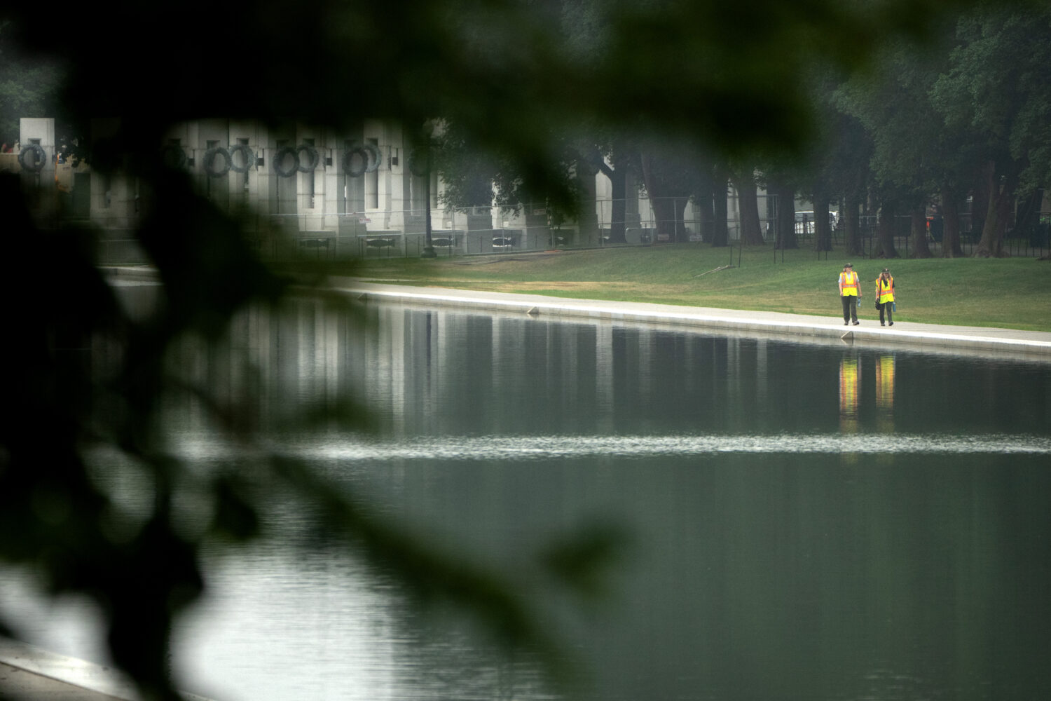 Workers pick up trash along the Lincoln Memorial Reflecting Pool, Tuesday, July 7, 2026, in Washing...