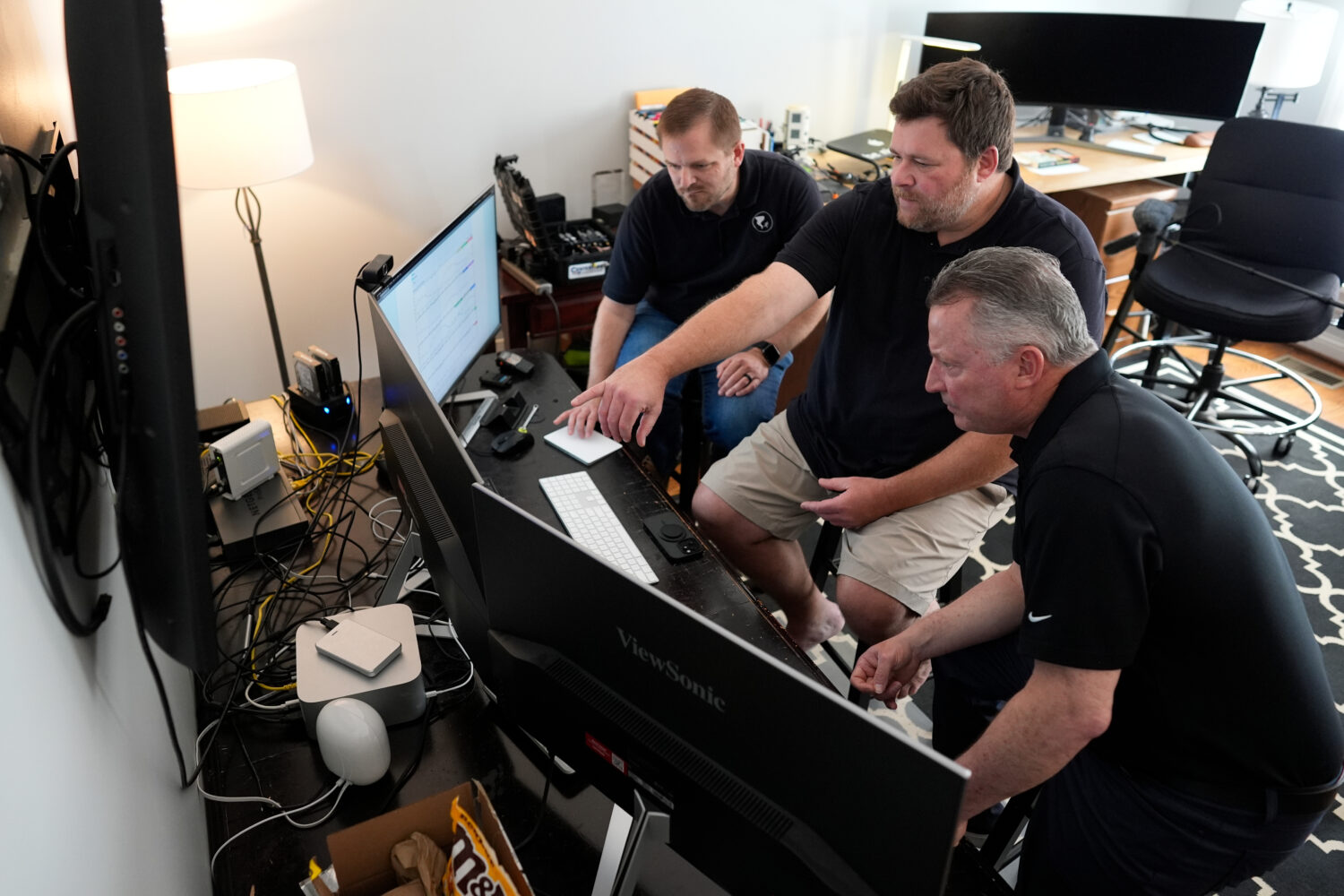 Andrew Leeper, left, Will Minkoff and Tom Johnstone, right, of Nashville Severe Weather, look over ...