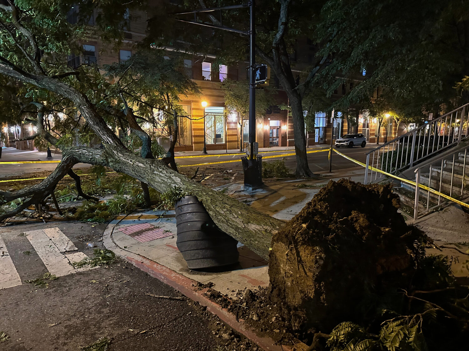 A tree ripped from the ground by a severe storm is surrounded by police tape in Hoboken, N.J., earl...