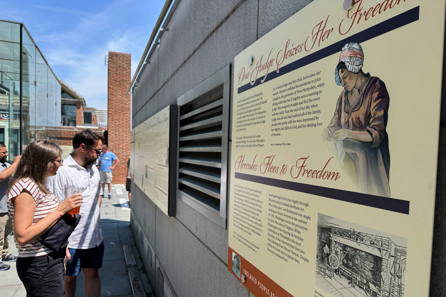 Visitors view the reinstalled educational panels about slavery at the site of President George Wash...