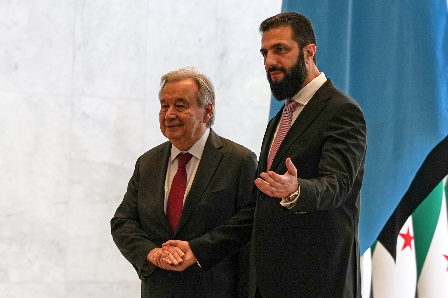 Syrian President Ahmad al-Sharaa, right, welcomes United Nations Secretary General Antonio Guterres...