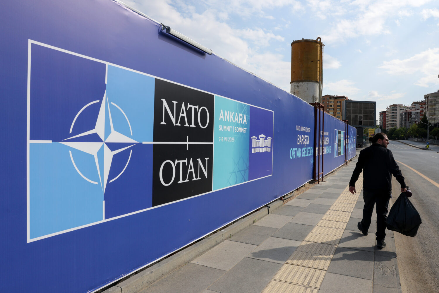 A man walks past a banner ahead of the NATO Summit in Ankara, Turkey, Sunday, July 5, 2026. (AP Pho...