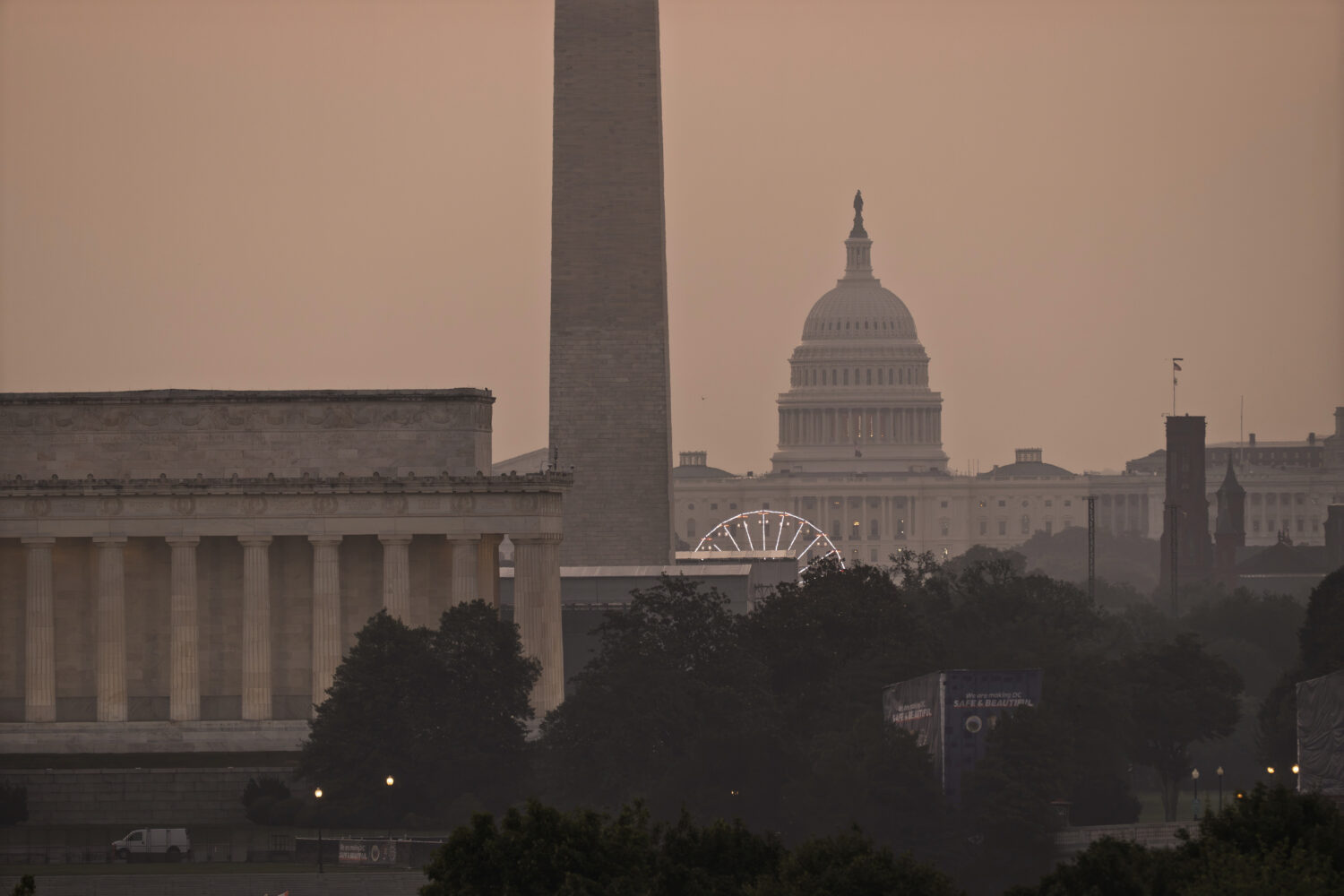The Lincoln Memorial, the Washington Monument, and the U.S. Capitol, are seen at dawn from an overl...