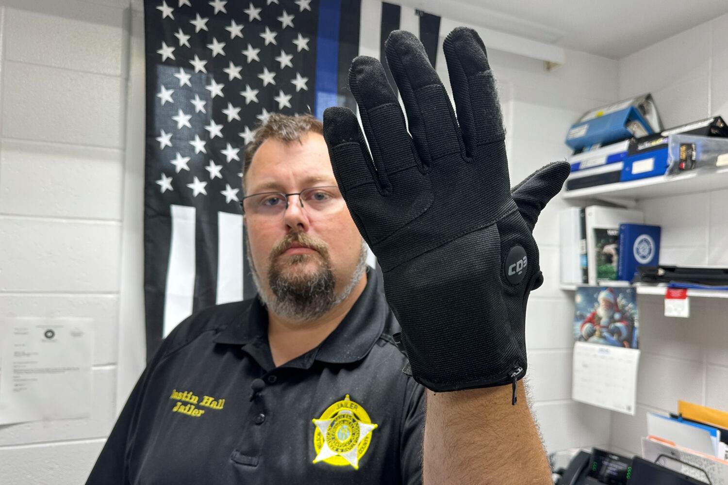 Nelson County, Ky., jailer Justin Hall shows an electric shock glove that is used at his facility, ...