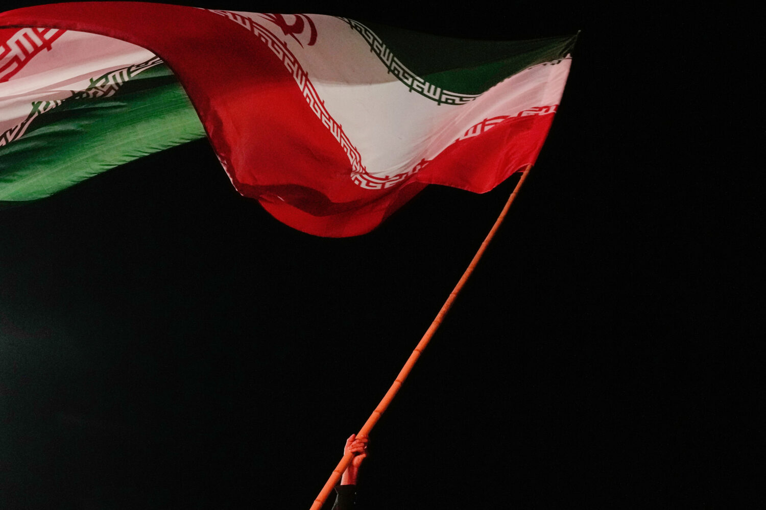 A man waves an Iranian flag during a pro-government gathering at a square in Tehran, Iran, Tuesday,...
