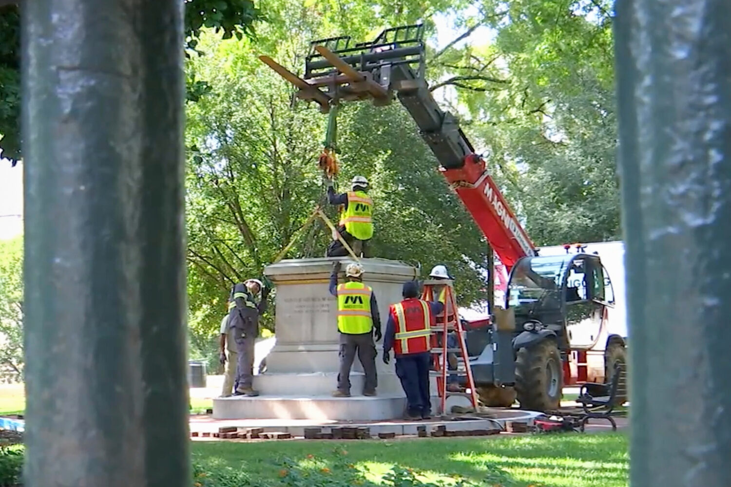 This image taken from a WRIC video shows workers attaching straps to a Confederate statue as they p...